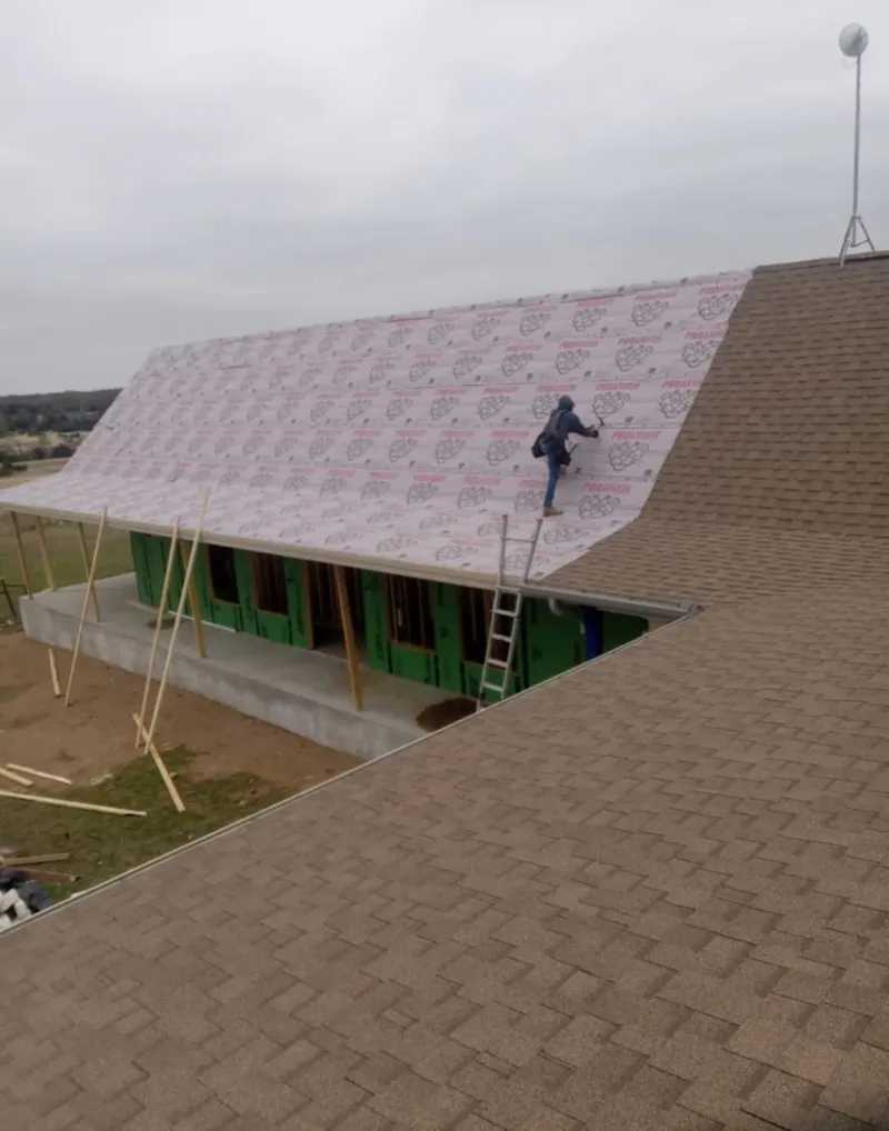 Worker preparing underlayment for a metal roof installation in Madera Ranchos